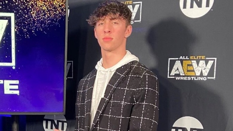 Nick Wayne in front of an AEW logo