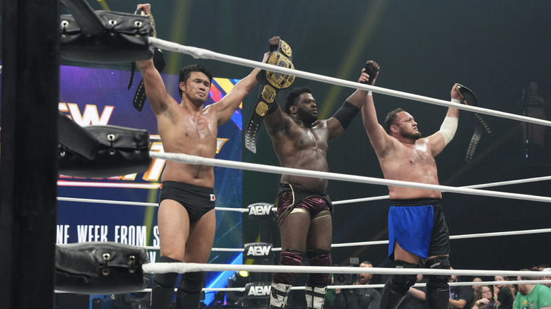 The Opps holding up the AEW World Trios Championship belts