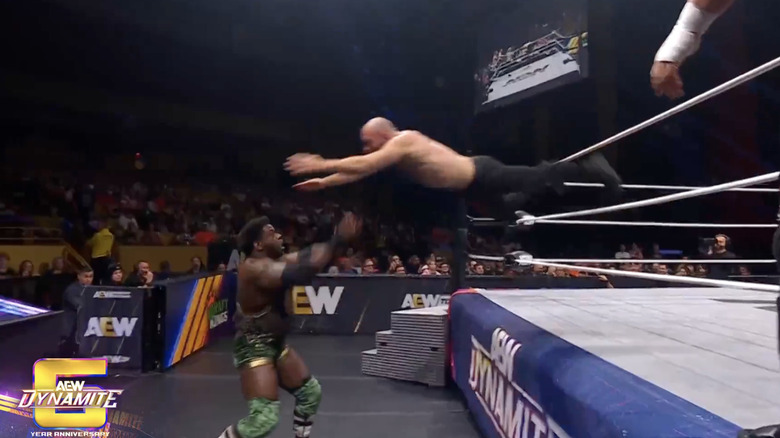 Moxley landing a dive on Hobbs on the outside
