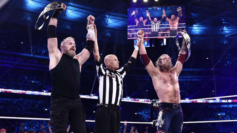 The referee raising Cage and Copeland's arms