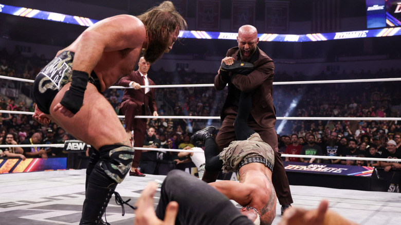 Alexander with an Ankle Lock cinched in on Allin as Davis watches next to him