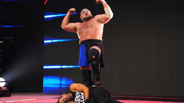 Samoa Joe Posing On top of Adam Cole 