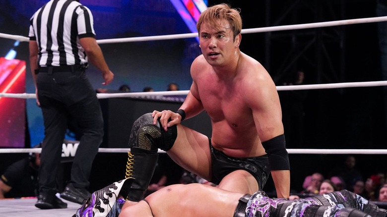 Kazuchika Okada, seated next to a prone Bandido