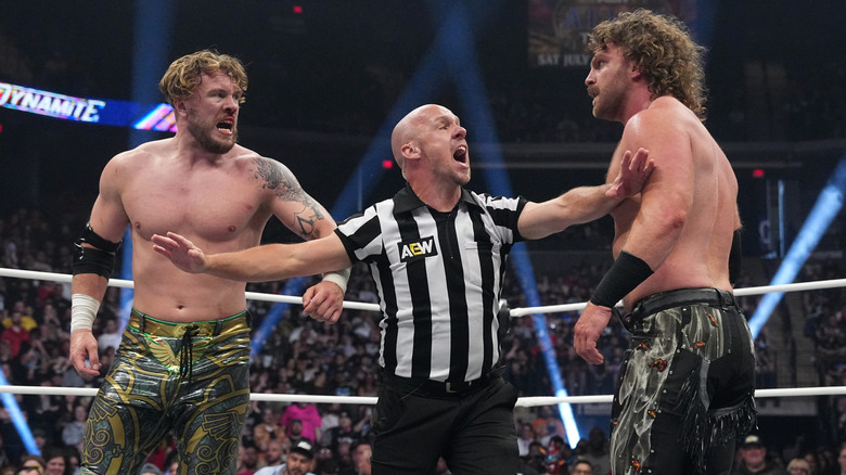 Referee Bryce Remsburg trying to keep Will Ospreay and 