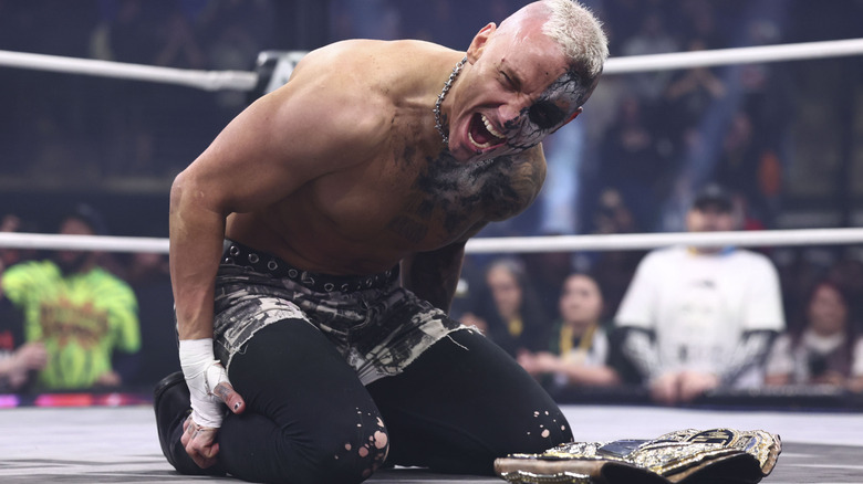 Darby Allin kneels over the AEW World Championship in the ring after defeating MJF on an episode of 