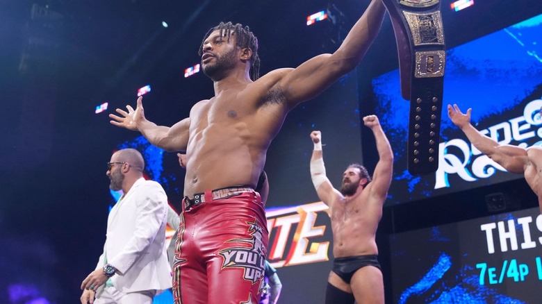 Kevin Knight poses with arms out among the Don Callis Family on "AEW Dynamite"