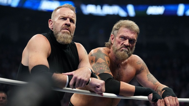Christian Cage and Adam Copeland look upset, leaning on the ropes