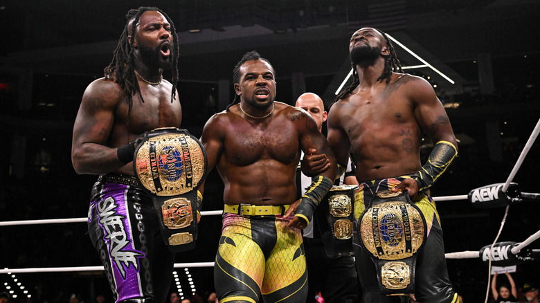 Swerve Strickland, Austin Creed, and Kofi hold their AEW World Trios Championships in the ring following a victory on the September 9, 2026 edition of "AEW Dynamite."
