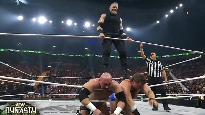 Cage jamming his boots into Harwood and Wheeler's spines