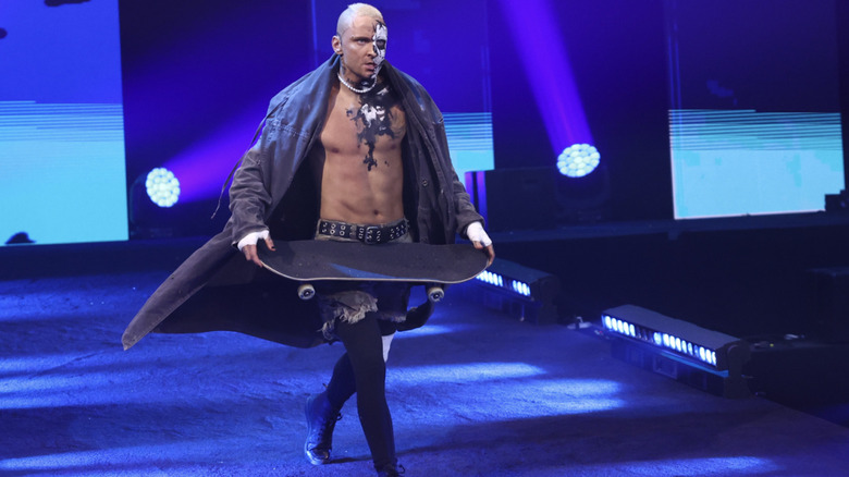 Allin running down the entrance ramp with his skateboard in hand