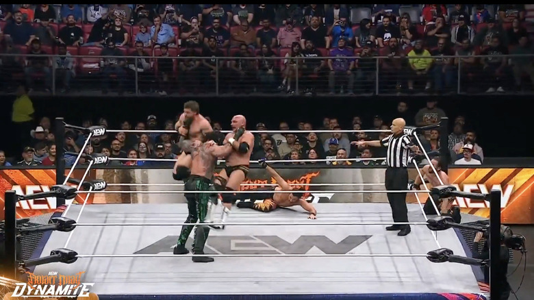 Luchasaurus landing a double chokeslam on Wheeler and Harwood