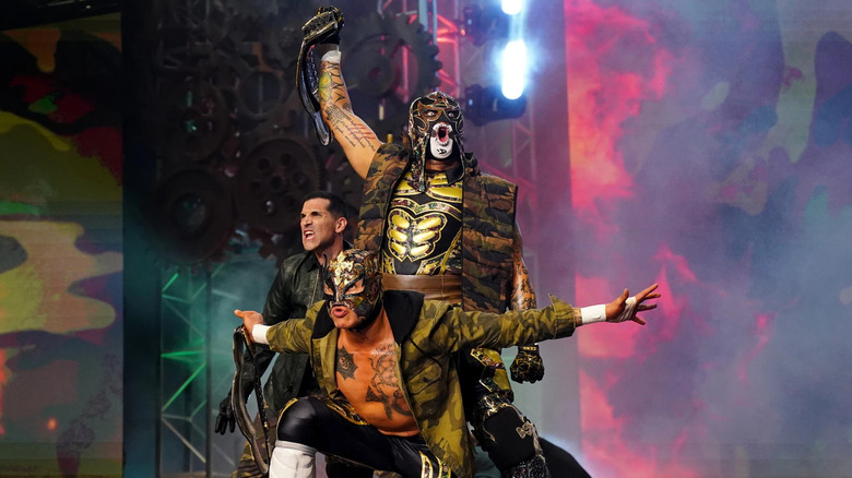 Penta and Rey Fenix pose on the stage, alongside Alex Abrahantes, before their match against FTR at Full Gear 2021.