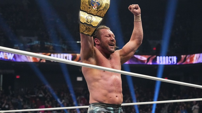 Kenny Omega holding aloft his International Championship