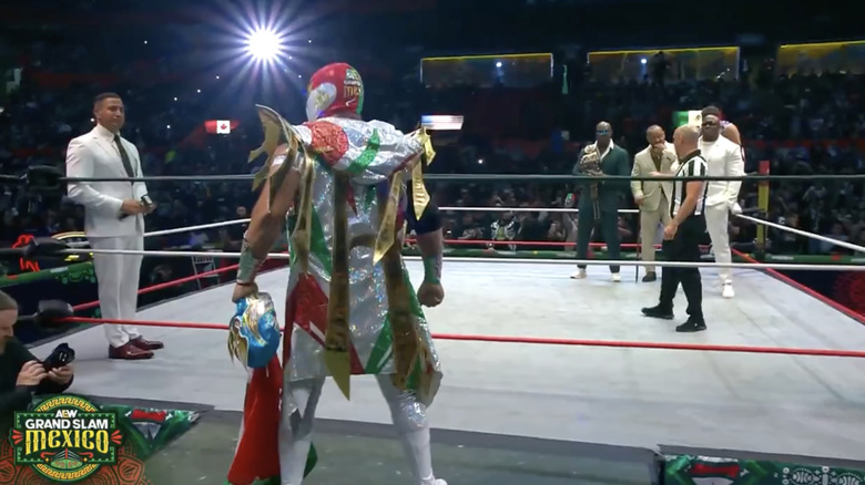 Mistico making his entrance as The Hurt Syndicate waits inside the ring
