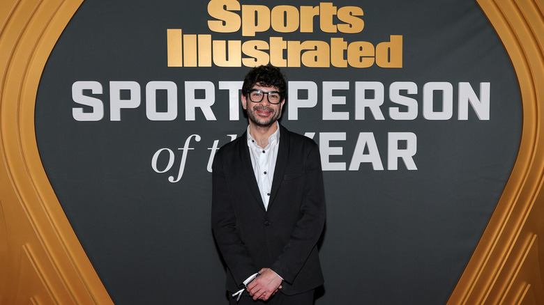 Tony Khan in front of a banner that reads Sports Illustrated Sportsperson of the Year