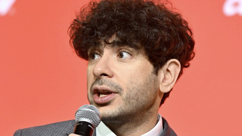 Tony Khan speaks into a microphone.