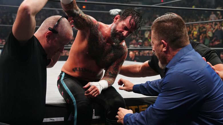 CM Punk is helped away from the ring