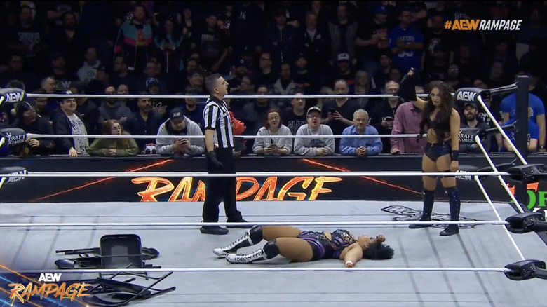 Blue holding up the bag of tacks in the ring