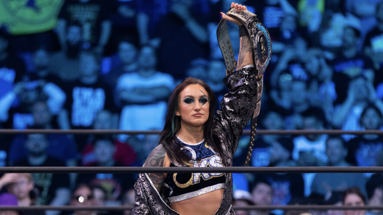 Kris Statlander holding up her title