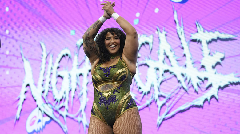 Willow Nightingale claps and poses on the stage before a match on an episode of AEW programming.