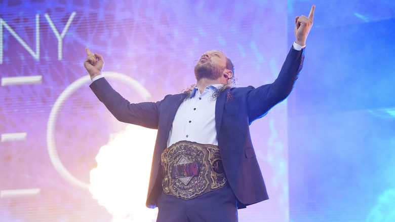 AEW World Champion Kenny Omega poses at the top of the stage, the title belt around his waist, during the July 15, 2026 edition of "AEW Dynamite."
