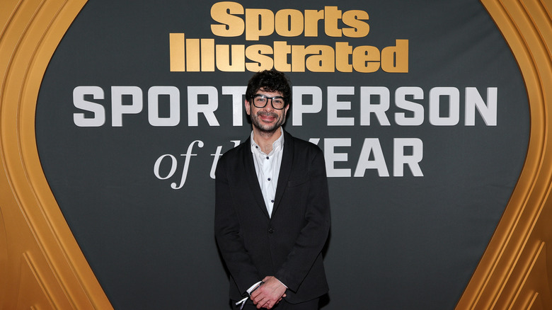 Tony Khan in front of a banner that reads Sports Illustrated Sportsperson of the Year