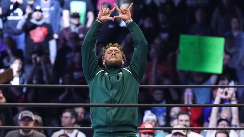Will Ospreay raises his arms and makes W sign with fingers
