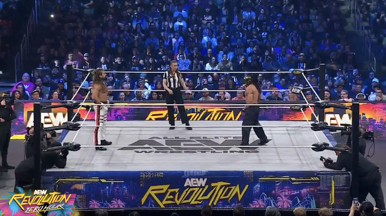 Andrade and Bandido in the ring staring one another down