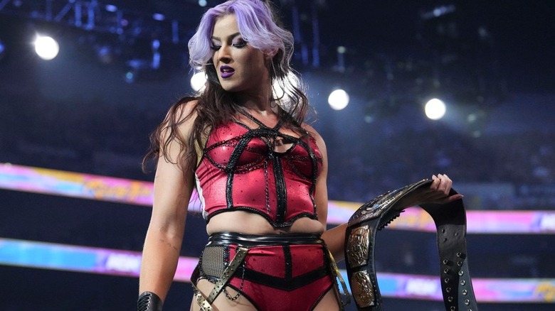 Lena Kross holding an AEW women's tag title belt at Revoution