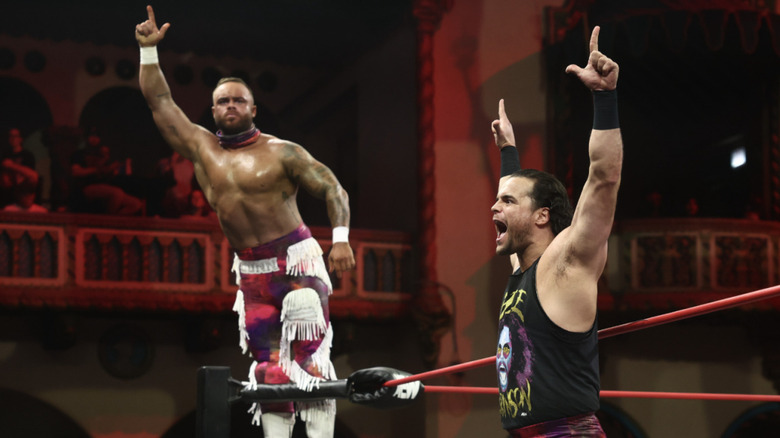 The Bang Bang Gang posing on the ring apron