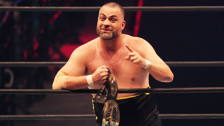 Eddie Kingston leaning on the ropes holding a title belt