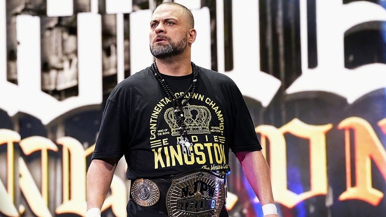 Eddie Kingston stands atop the entrance ramp with the NJPW Strong Championship around his waist