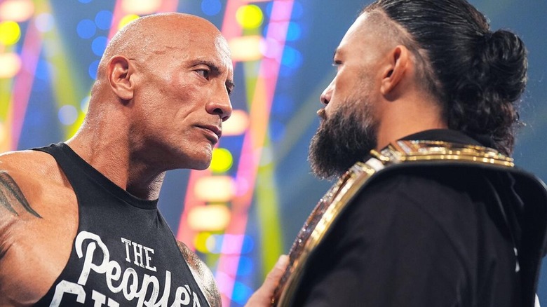 The Rock intensely staring down Roman Reigns during an in ring segment ahead of WrestleMania.