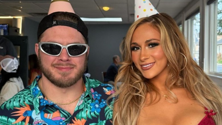 Joey Janela and Megan Bayne pose in party hats in a smiling photo posted to Instagram.