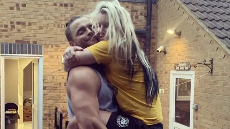 Toni Storm jumps into the arms of husband Juice Robinson outside of a home in a photo posted to her Instagram account.
