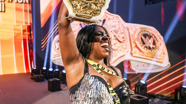 Naomi raises the WWE Women's World Championship following her Money in the Bank cash-in.