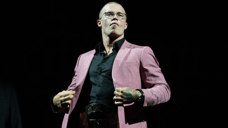 Kyle Fletcher wearing glasses and a pink jacket