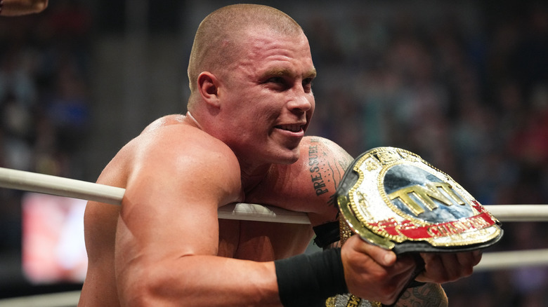 Kyle Fletcher poses with the TNT Championship as he looks through the ropes at AEW WrestleDream 2025.