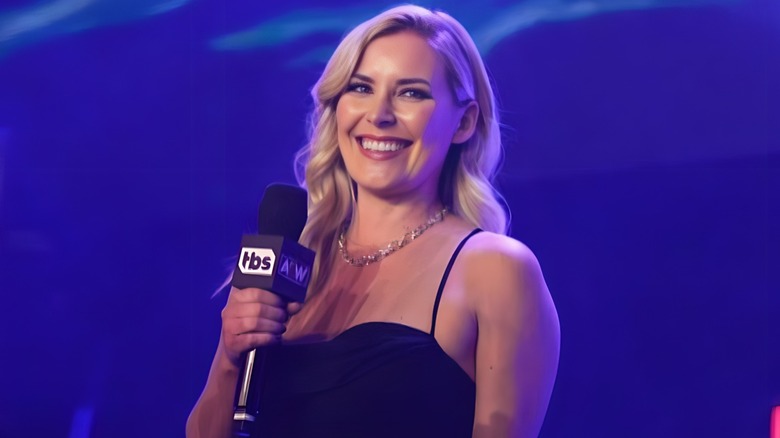 Renee Paquette holding AEW TBS microphone wearing black dress