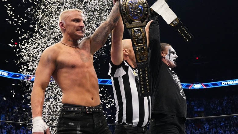 Darby Allin and Sting holding up tag title belts