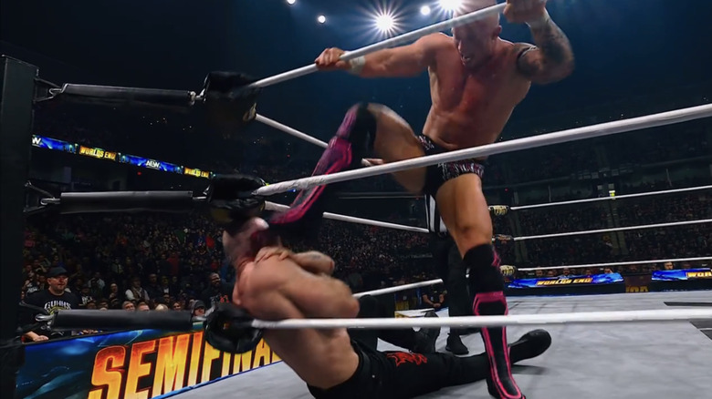 Kyle Fletcher lays aggressive stomps onto a cornered Jon Moxley.