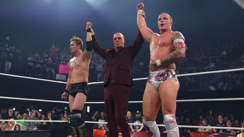 Kyle Fletcher celebrates victory with Don Callis and Kazuchika Okada