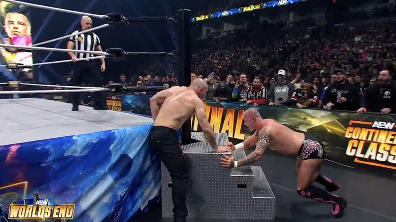 Fletcher jamming Moxley's leg into the ring steps