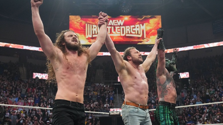 Kenny Omega celebrates with Jurassic Express.