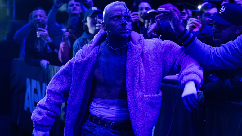 Darby Allin leans on the barricade near the fans, looking exasperated toward the ring, during an episode of "AEW Dynamite."