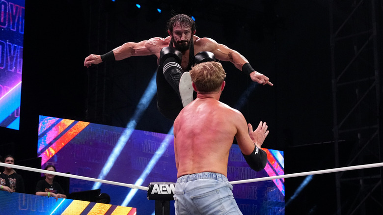 PAC hits Orange Cassidy with a kick to the face, and the photo is capture while he's in mid-air while jumping from the photos, on an episode of 