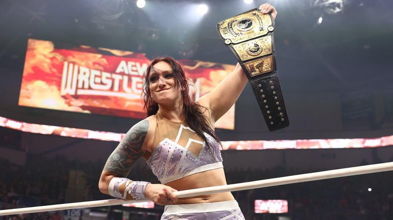 Kris Statlander holds up the AEW Women's World Championship as she stares at Mercedes Mone from the ring during AEW WrestleDream.
