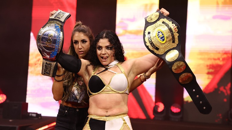 Persephone celebrates, with Britt Baker over her shoulder