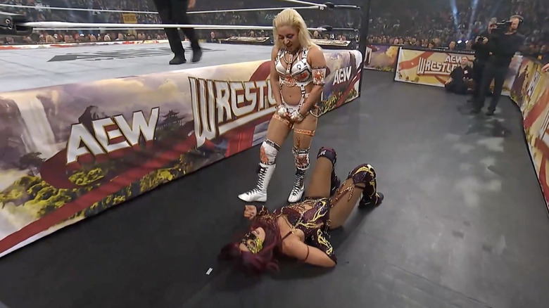 Thekla standing over Mone on the outside