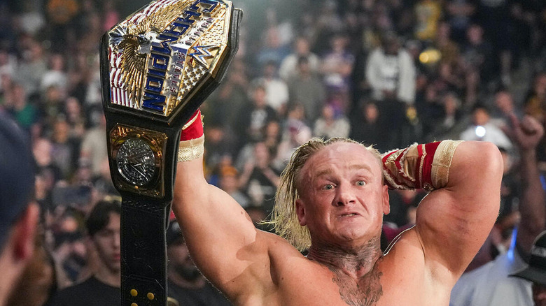 Ilja Dragunov holding the Men's US title in the air